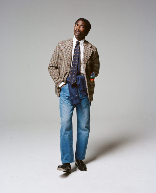 A houndcheck tweed Games jacket worn with a knit tie and light jeans, from the Drake's autumn campaign