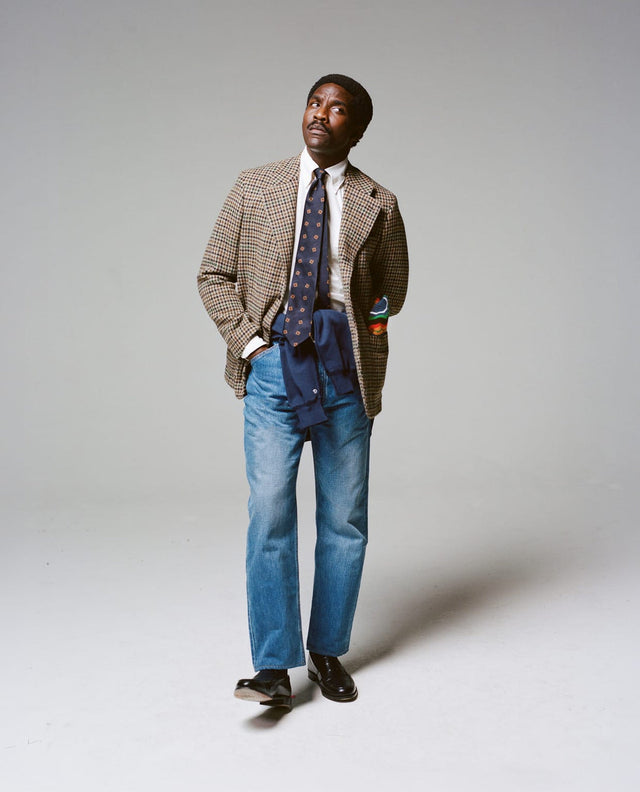 A houndcheck tweed Games jacket worn with a knit tie and light jeans, from the Drake's autumn campaign