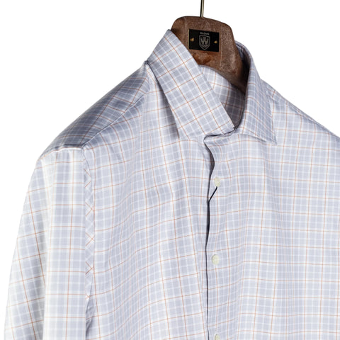 A light blue and white plaid button-down shirt hanging on a wooden hanger against a neutral light gray background.