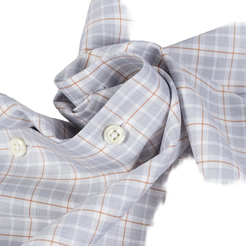 Close-up of a light gray plaid shirt fabric with thin orange-brown grid lines and white buttons.