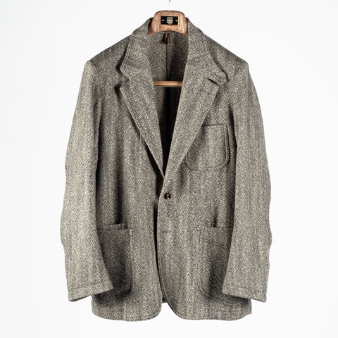 Drake's Black and White Tweed Western Games Blazer shown front on and buttoned on a wooden hanger.