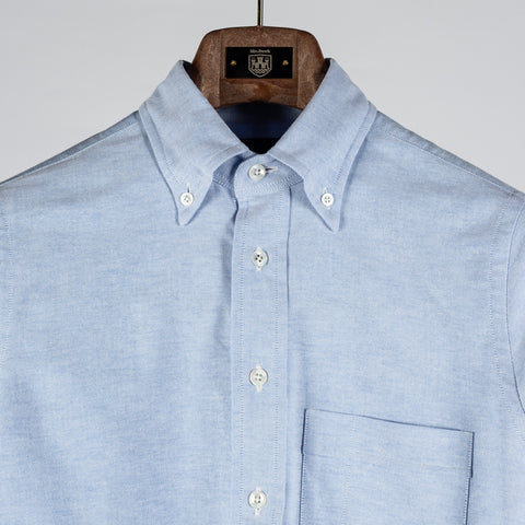 Drake's ice blue oxford cloth button-down shirt in close up, with the collar rolling over the placket.