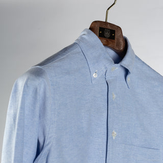 Drake's ice blue oxford cloth button-down shirt at an angle, showing the rolling collar and buttoned collar points.