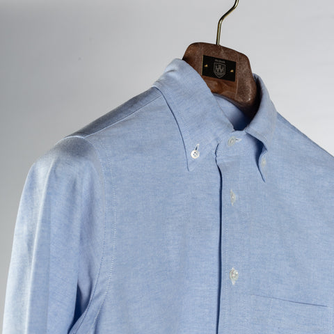 Drake's ice blue oxford cloth button-down shirt at an angle, showing the rolling collar and buttoned collar points.