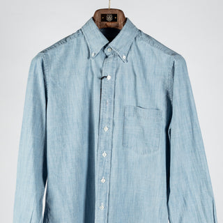 Drake's light blue chambray button-down shirt from the front, cropped to the chest pocket and shoulders.
