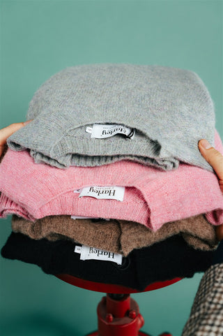 Harley of Scotland Shaggy sweaters stacked with woven labels showing, the Tundra camel crew neck among them