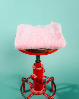 Sakura Shaggy crew neck sweater folded on a red workshop stool