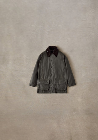 Barbour Olive Classic Beaufort Wax Jacket styled flat on a stone backdrop.