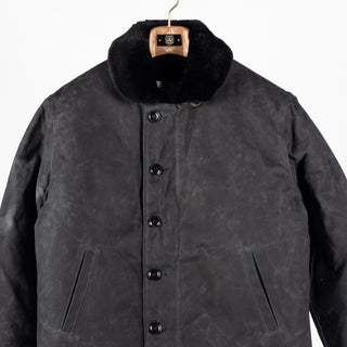 Black/Black waxed canvas N-1 Deck Jacket with black mouton collar, front, close view of the buttons and pockets