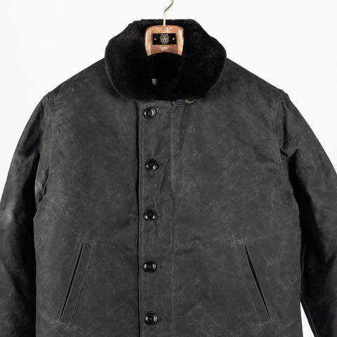 Black/Black waxed canvas N-1 Deck Jacket with black mouton collar, front, close view of the buttons and pockets