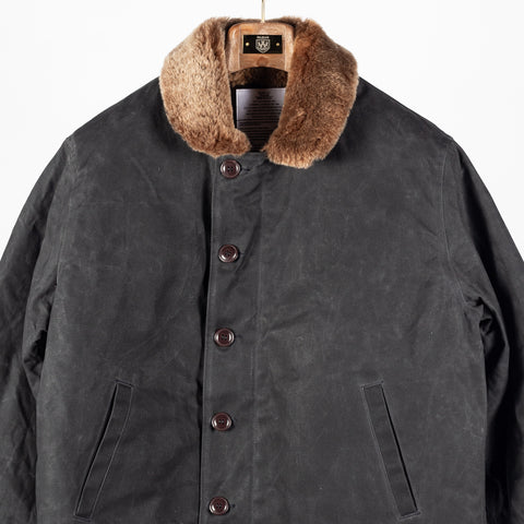Black/Kodiak waxed canvas N-1 Deck Jacket with brown Kodiak mouton collar, front, close view of the buttons and pockets