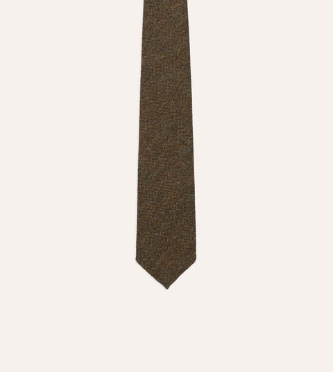 Blade and point of Drake's brown and black herringbone wool tie, close on the weave.