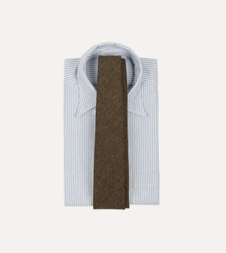 Drake's brown and black herringbone wool tie laid over a folded blue and white striped button-down oxford shirt.