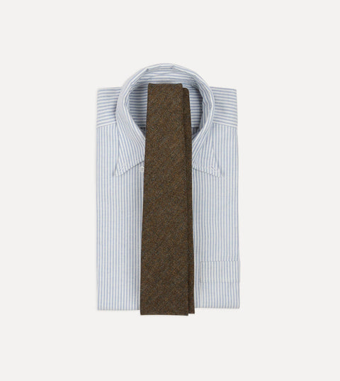 Drake's brown and black herringbone wool tie laid over a folded blue and white striped button-down oxford shirt.