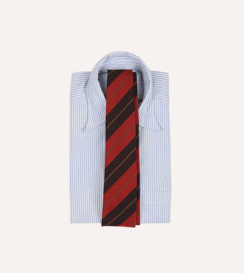 Brown, gold and red cashmere cotton stripe tie laid over a folded blue striped oxford shirt