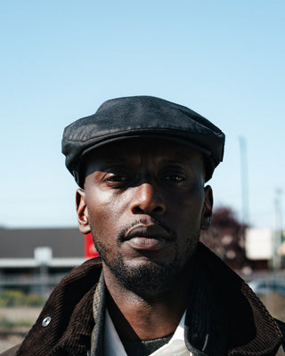 Barbour Black Cheviot Waxed Flat Cap worn with a waxed jacket