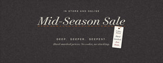Mid-Season Sale. In store and online. Deep, deeper, deepest. Hard-marked prices, no codes, no stacking. Final sale tag hanging from an orange stitch on charcoal herringbone cloth.