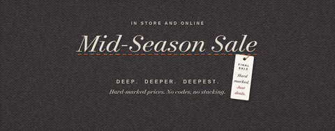 Mid-Season Sale. In store and online. Deep, deeper, deepest. Hard-marked prices, no codes, no stacking. Final sale tag hanging from an orange stitch on charcoal herringbone cloth.