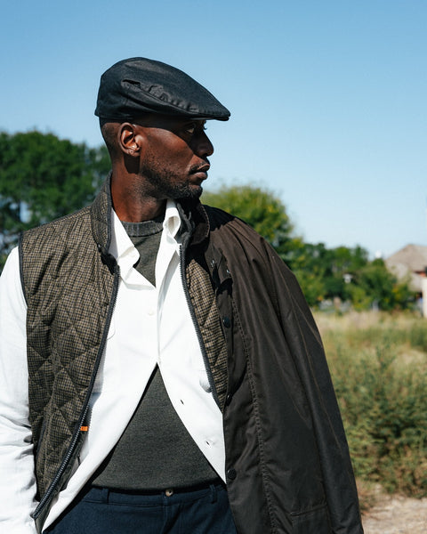 Waterville Olive Check Theo Quilted Vest worn over a white shirt with a waxed flat cap