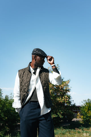 Waterville Olive Check Theo Quilted Vest open over a white shirt and navy wool trousers