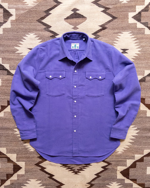 Wythe purple moleskin pearlsnap shirt laid flat on a rug