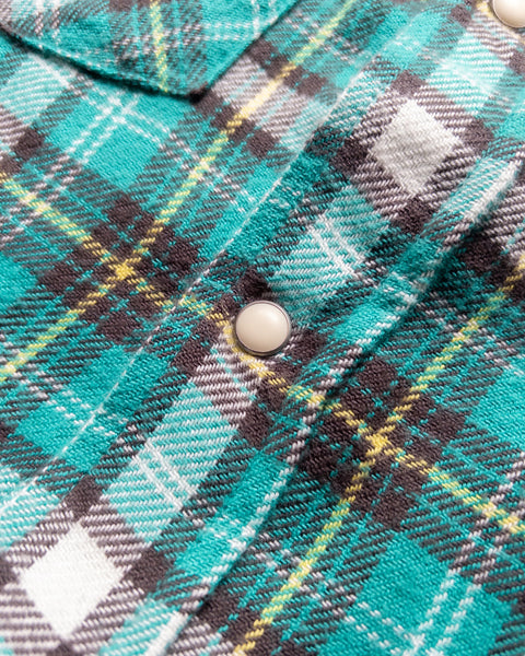 Close-up of a cream pearl snap on the Thousand Lakes Plaid brushed flannel